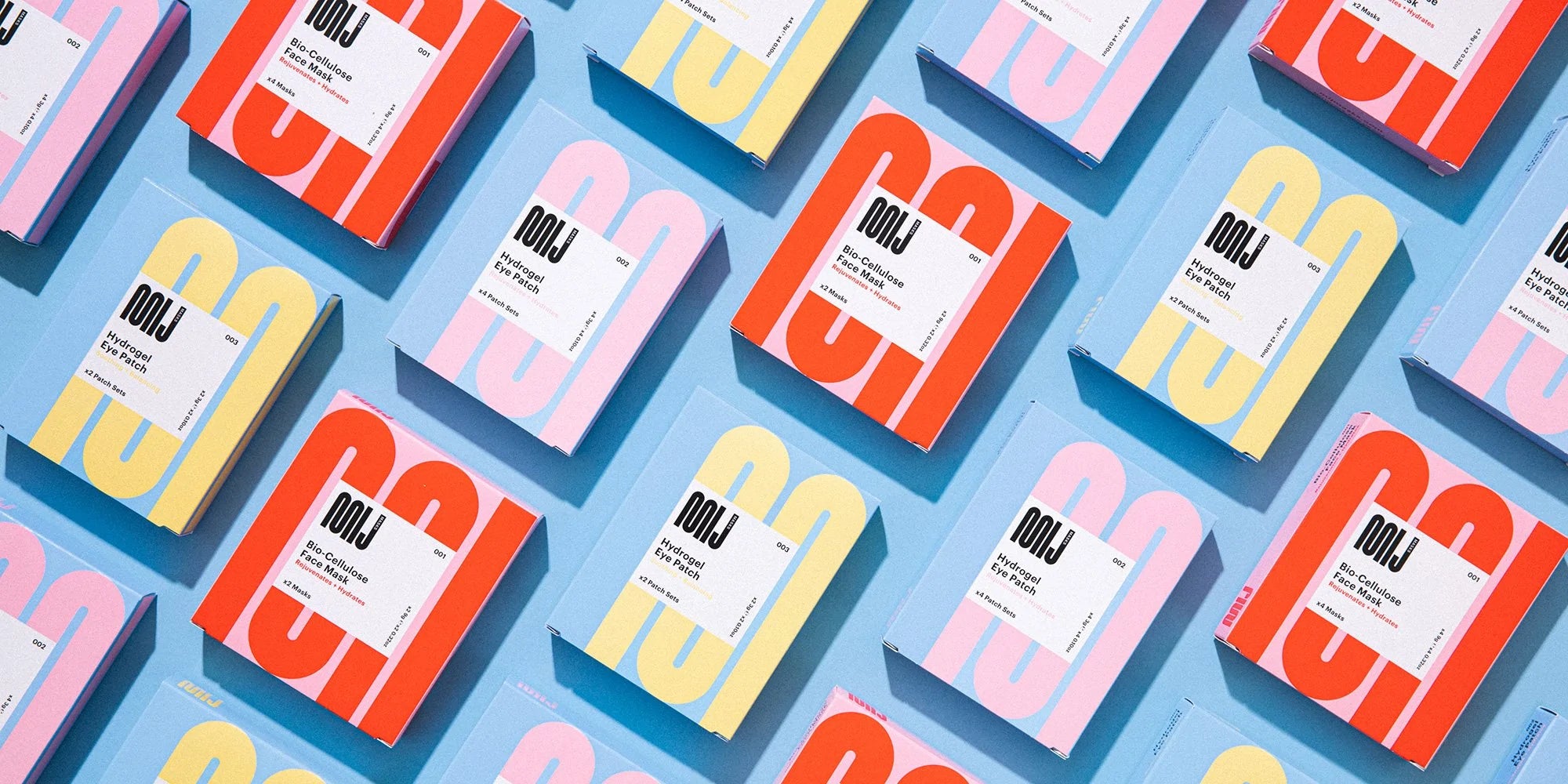 An array of boldly colored boxes branded 'MIJ' are lined up on a blue surface