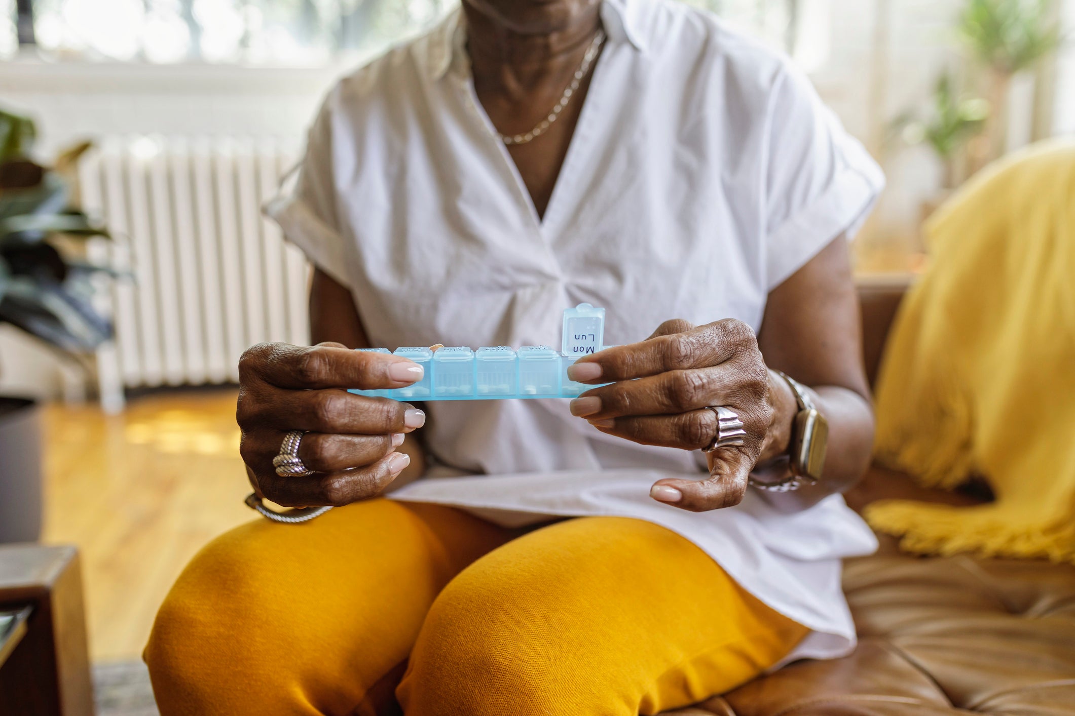 Une femme prenant des suppléments quotidiens dans un pilulier