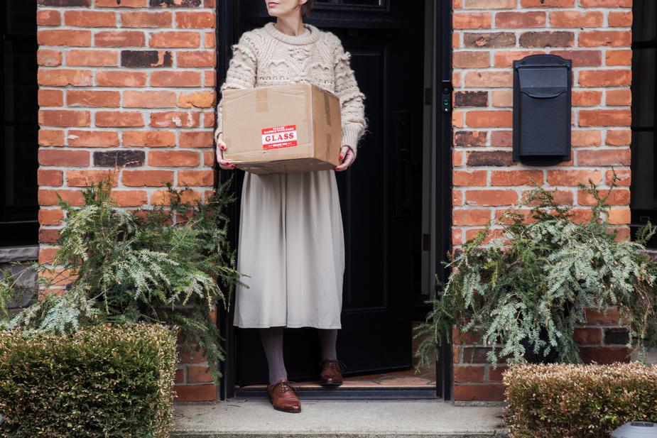 A woman collects a package from her doorstep